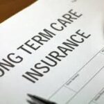 Long term care insurance form with reading glasses resting on top, representing elder care planning and insurance documentation